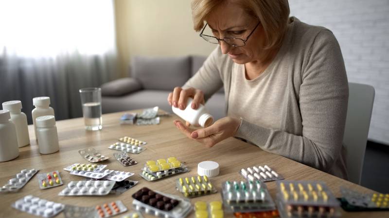 Woman organizing tablets from several medication blister packs